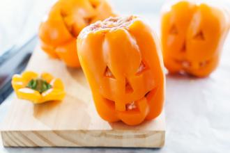 Jack-o-lantern bell peppers sitting on counter.