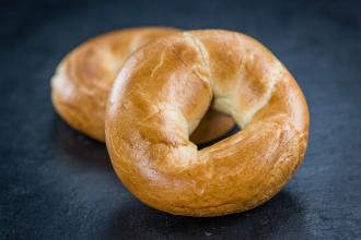 Two homemade bagels stacked on black table