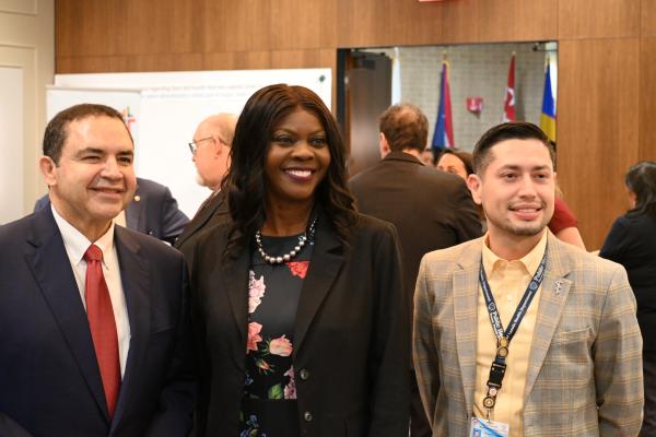 Congressman Henry Cuellar (D-TX), Dr. Chavonda Jacobs-Young, USDA Under Secretary for  Research, Education, and Economics and USDA Chief Scientist, and Dr. Richard Chamberlain, Director of the  City of Laredo Public Health Department, standing together and smiling.