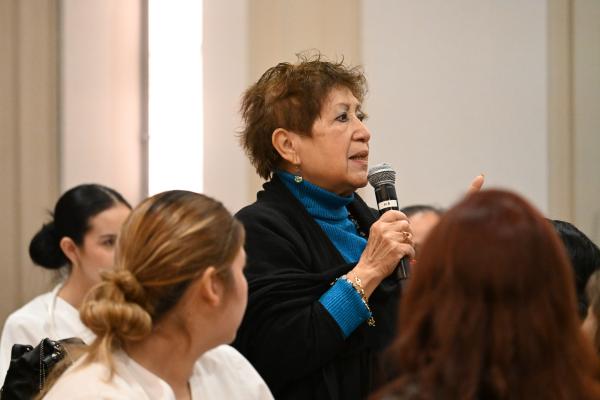 A community member standing and speaking to other meeting participants about food,  nutrition, and health. 